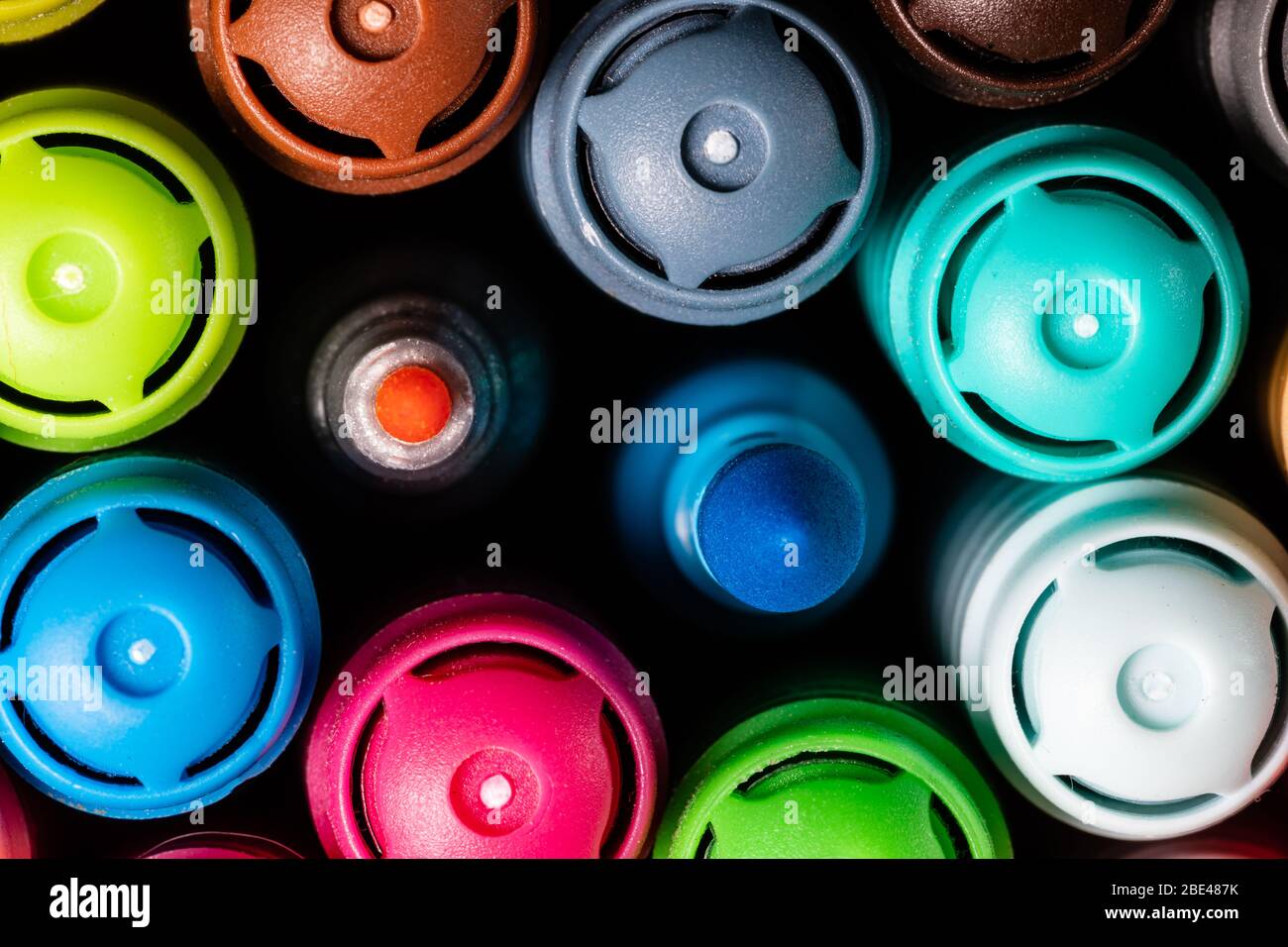 Immagine macro di un set di marcatori colorati dell'artista in una tazza strettamente raggruppati con i cappucci rivolti verso l'alto con una punta larga turchese e una punta fine rosa m Foto Stock
