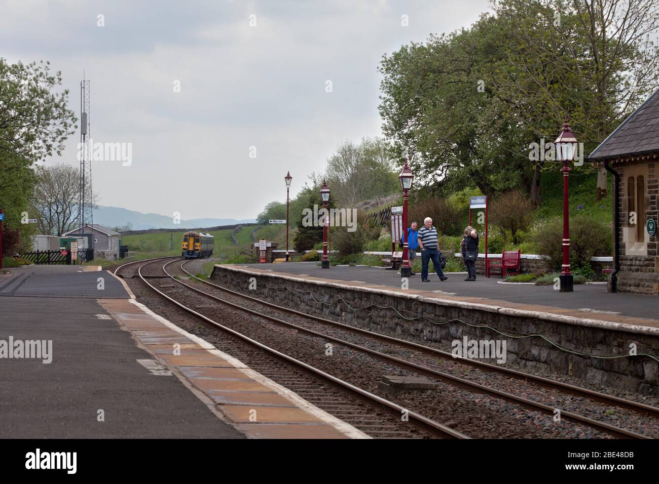Treno Nord / treni Nord classe 158 treno sprinter 158861 arrivo a Horton nella stazione ferroviaria di Ribblesdale con passeggeri in attesa Foto Stock