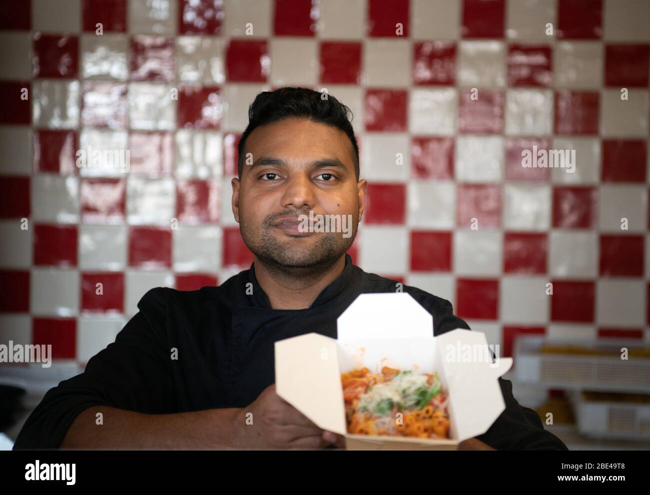 Potsdam, Germania. 07 aprile 2020. Lo chef Shakeel ha preparato una porzione di penne con salsiccia nel ristorante "Genusswerkstatt" al Filmmuseum e ha messo il cibo in una scatola per l'ordine "fuori casa". Non è consentito sedersi e mangiare nei ristoranti durante le restrizioni imposte dal pericolo di Corona. (Per 'Cool drinks and Delicious risotto: To Go in Sign of Corona') credito: Soeren Stache/dpa-Zentralbild/ZB/dpa/Alamy Live News Foto Stock