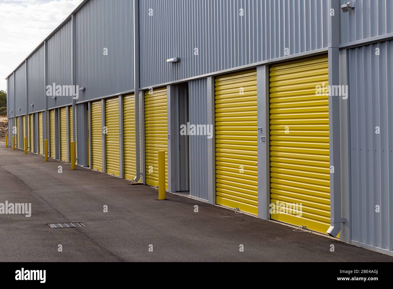 Moderno magazzino merci con porte a rulli gialle e edificio in acciaio o metallo Foto Stock