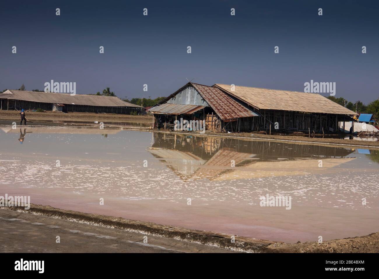 Il sale viene prodotto dall'evaporazione dell'acqua di mare; poi raccolto dai salini e conservato in edifici tradizionali a Pak Thale. Foto Stock