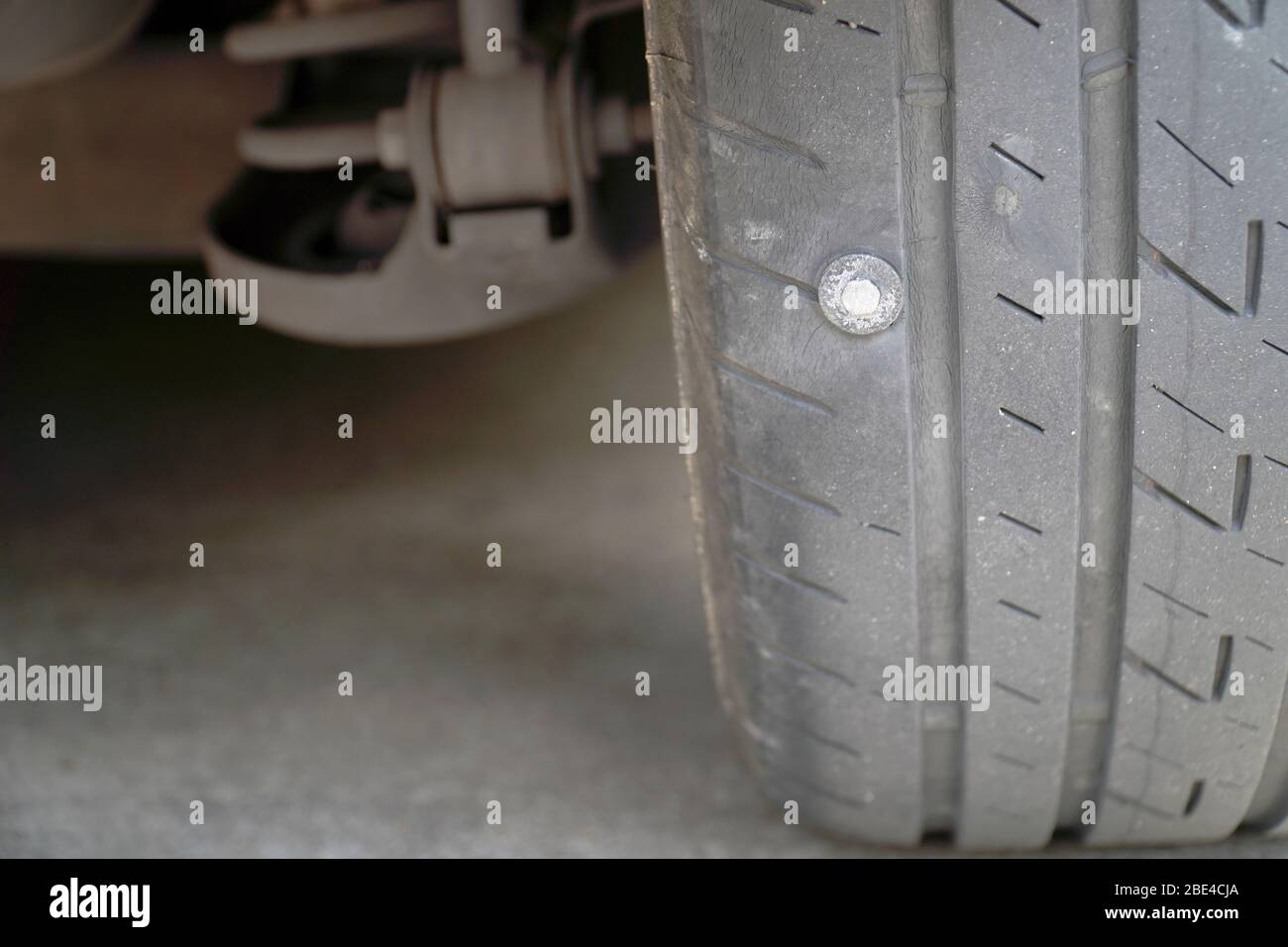 Primo piano dello pneumatico dove la vite è bloccata, causando la perdita dello pneumatico, la maggior parte dei problemi che causano lo sgonfio degli pneumatici. Foto Stock