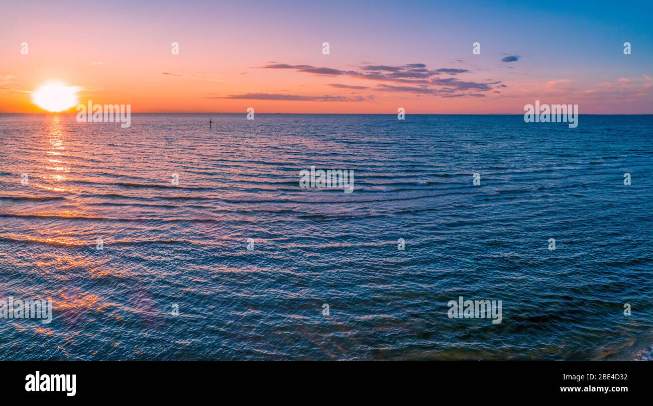 Panorama aereo del sole tramontare sul mare Foto Stock