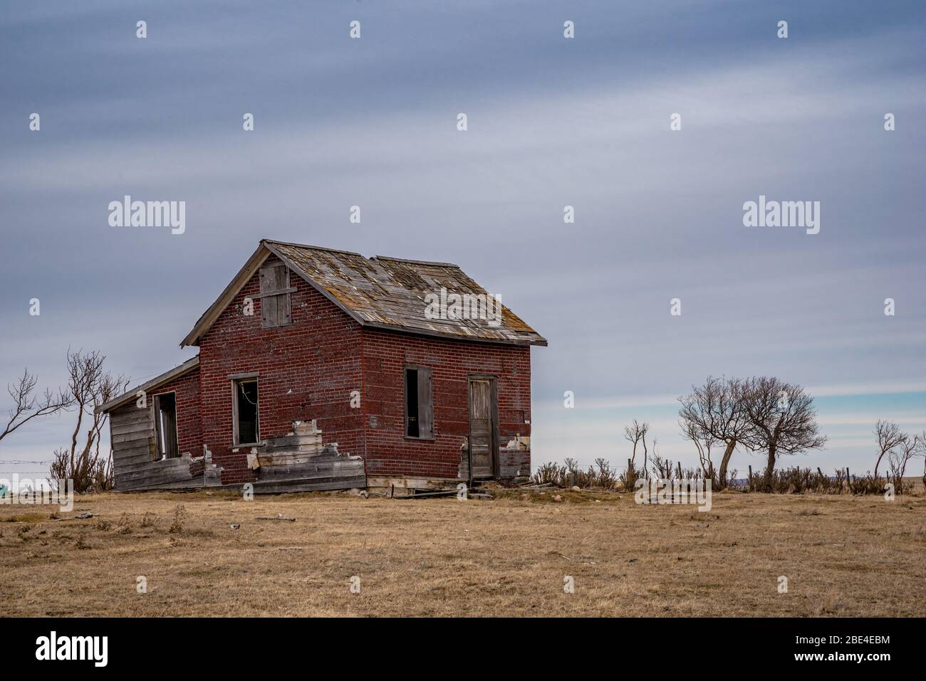 Un casale abbandonato in mattoni rossi in un cortile vicino a Coderre, Saskatchewan Foto Stock