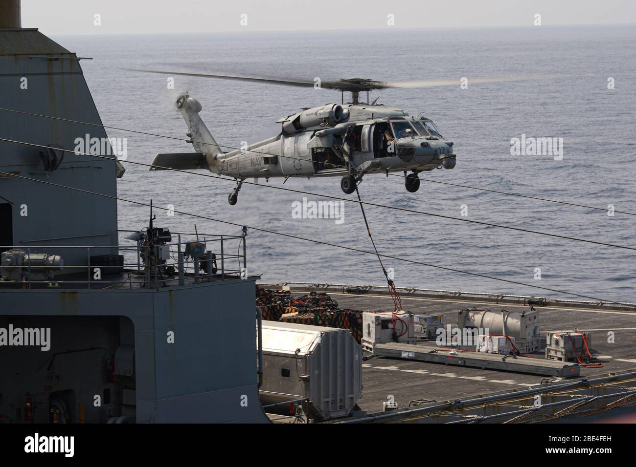 200401-N-FS718-1025 ARABIAN SEA (1 aprile 2020) un MH-60S Seahawk attaccato ai 'Dogs sty' di elicottero Sea Combat Squadron 7 sposta le forniture dalla USNS Robert E. Peary (T-AKE-5) durante un rifornimento verticale con la portaerei USS Dwight D. Eisenhower (CVN 69) 1 aprile 2020. IKE è distribuito nell'area operativa della 5th Fleet statunitense a sostegno delle operazioni navali per garantire stabilità e sicurezza marittima nella regione centrale, collegando il Mediterraneo e il Pacifico attraverso l'Oceano Indiano occidentale e tre punti di strozzatura strategici. (STATI UNITI Foto Navy di Aircrew Survival Equipmen Foto Stock