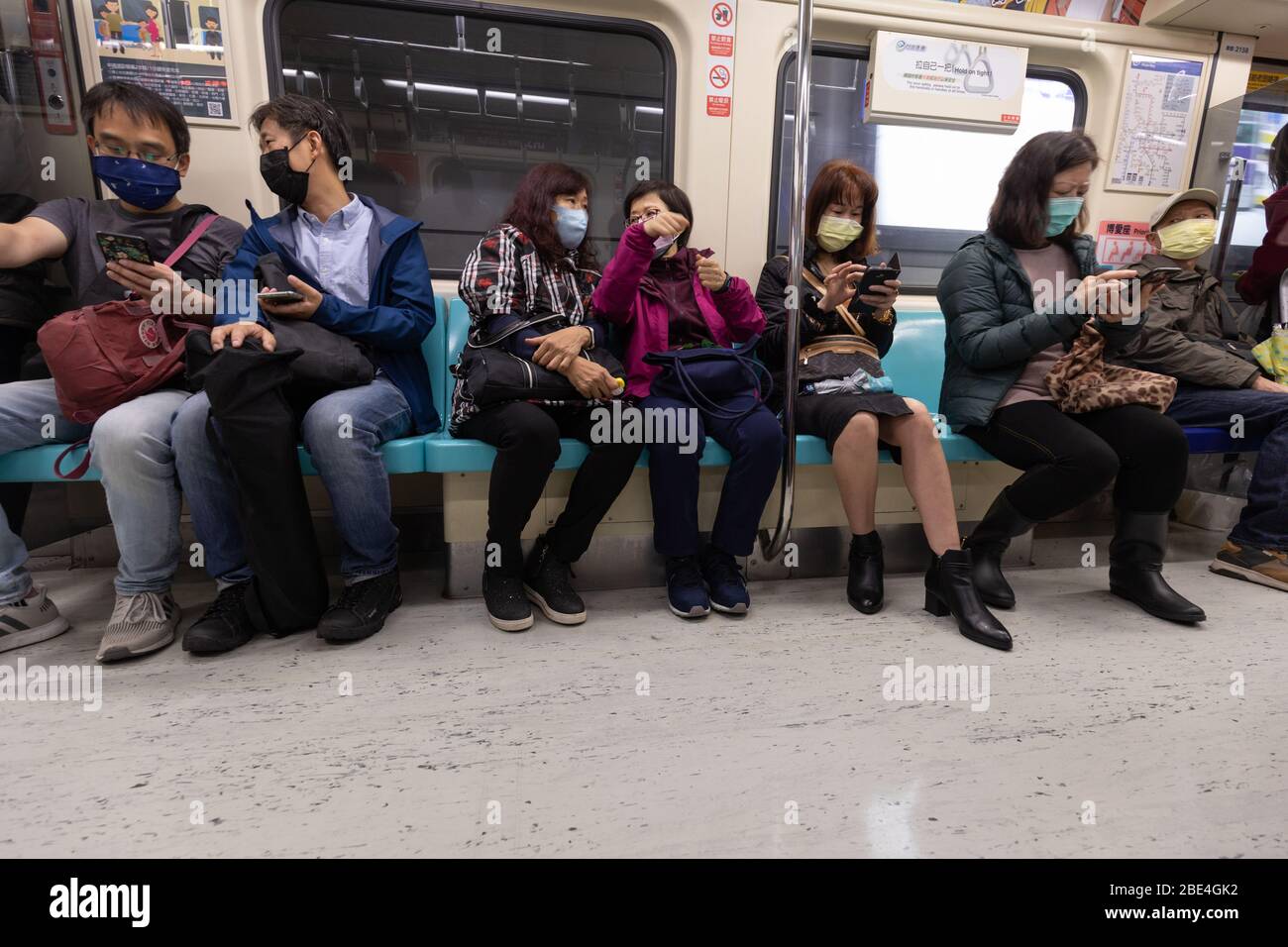 I pendolari della metropolitana di Taipei indossano maschere chirurgiche come protezione contro il coronavirus Covid-19. Foto Stock