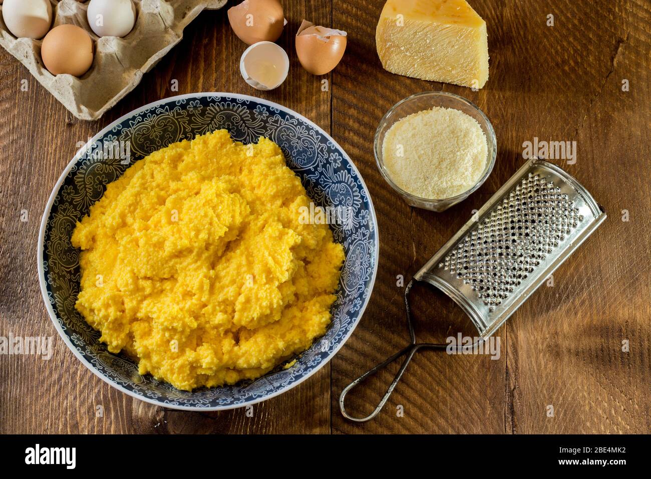 La foto mostra l'impasto di uova e formaggio, tipico ripieno pasquale campano utilizzato per riempire i panzerotti su sfondo ligneo Foto Stock