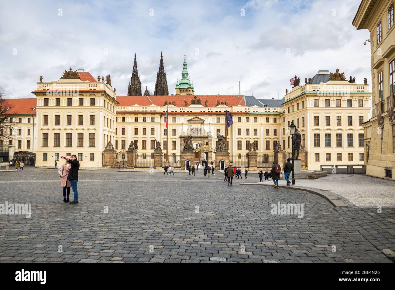 PRAGA, REPUBBLICA CECA - 10 MARZO 2020: Piazza Hradcanske, il Castello di Praga e il nuovo Palazzo reale. I turisti prendono selfie sullo sfondo delle attrazioni turistiche Foto Stock