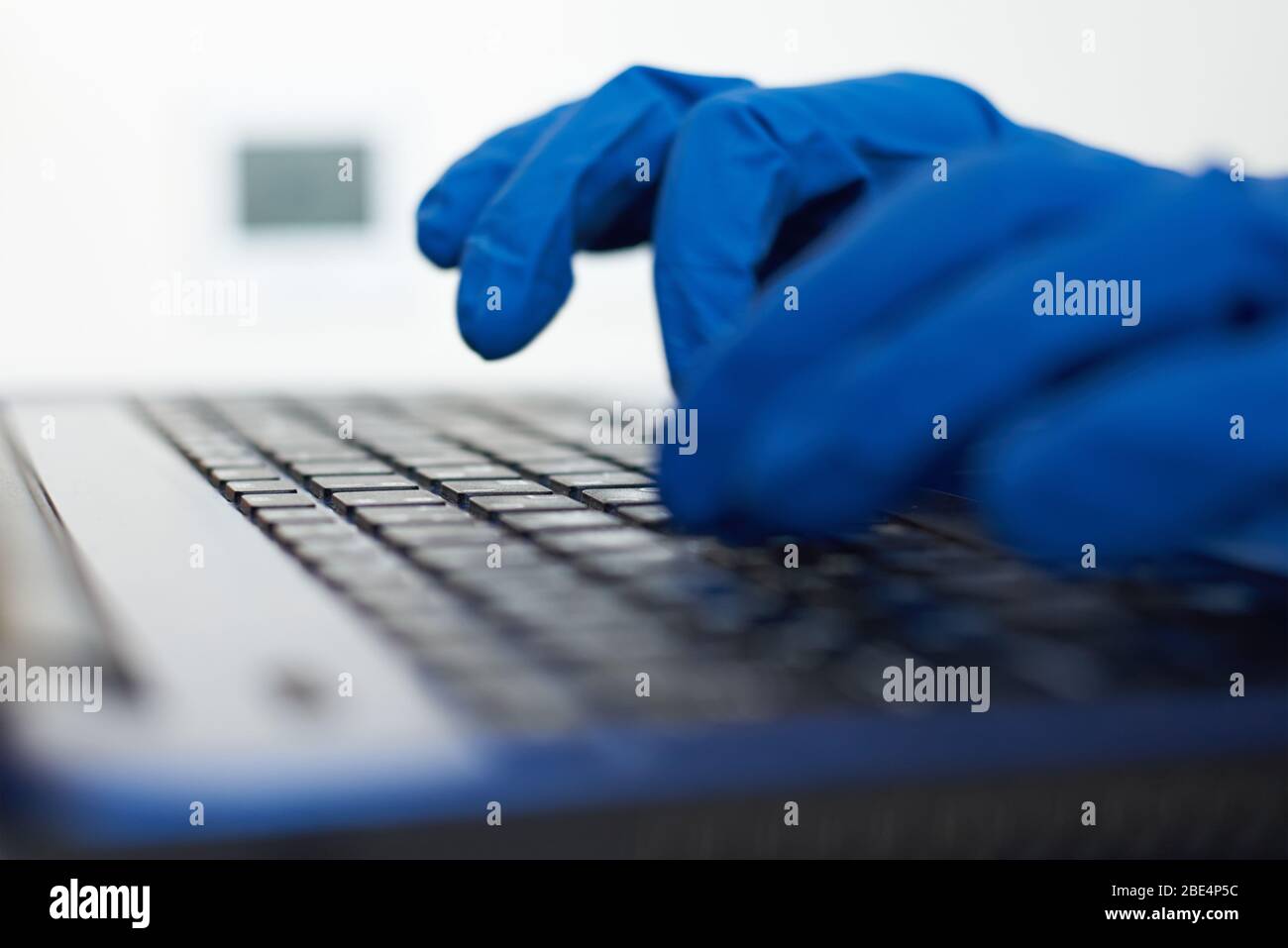 Indossare guanti protettivi sulla tastiera del notebook. Protezione dal concetto di coronavirus covid-19 Foto Stock
