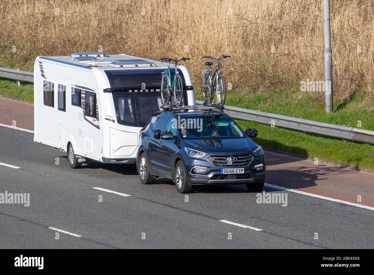 2016 blu Hyundai Santa FE Prem se Bdrive C traino Coachman VIP 545 caravan: Veicoli a circolazione veicolare, veicolo di guida su strade britanniche, motori, portabiciclette montato sul tetto, portabiciclette sul tetto, portabiciclette, portabiciclette, ciclisti che viaggiano sull'autostrada M6 Foto Stock