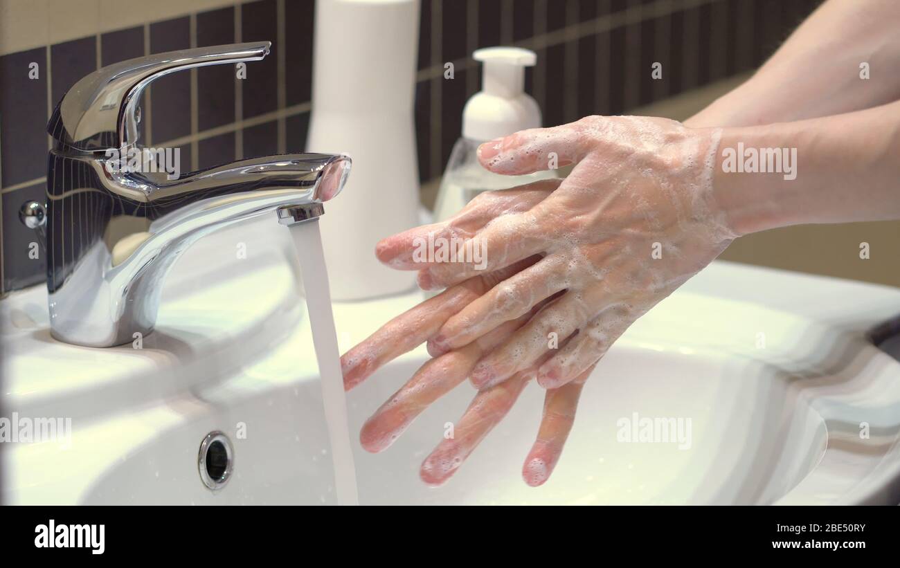 La giusta tecnica per una buona igiene delle mani per proteggersi dai germi e dal coronavirus Covid19. Sporcamento prolungato, sfregamento e lavaggio delle mani con acqua. Vista ravvicinata. Foto Stock