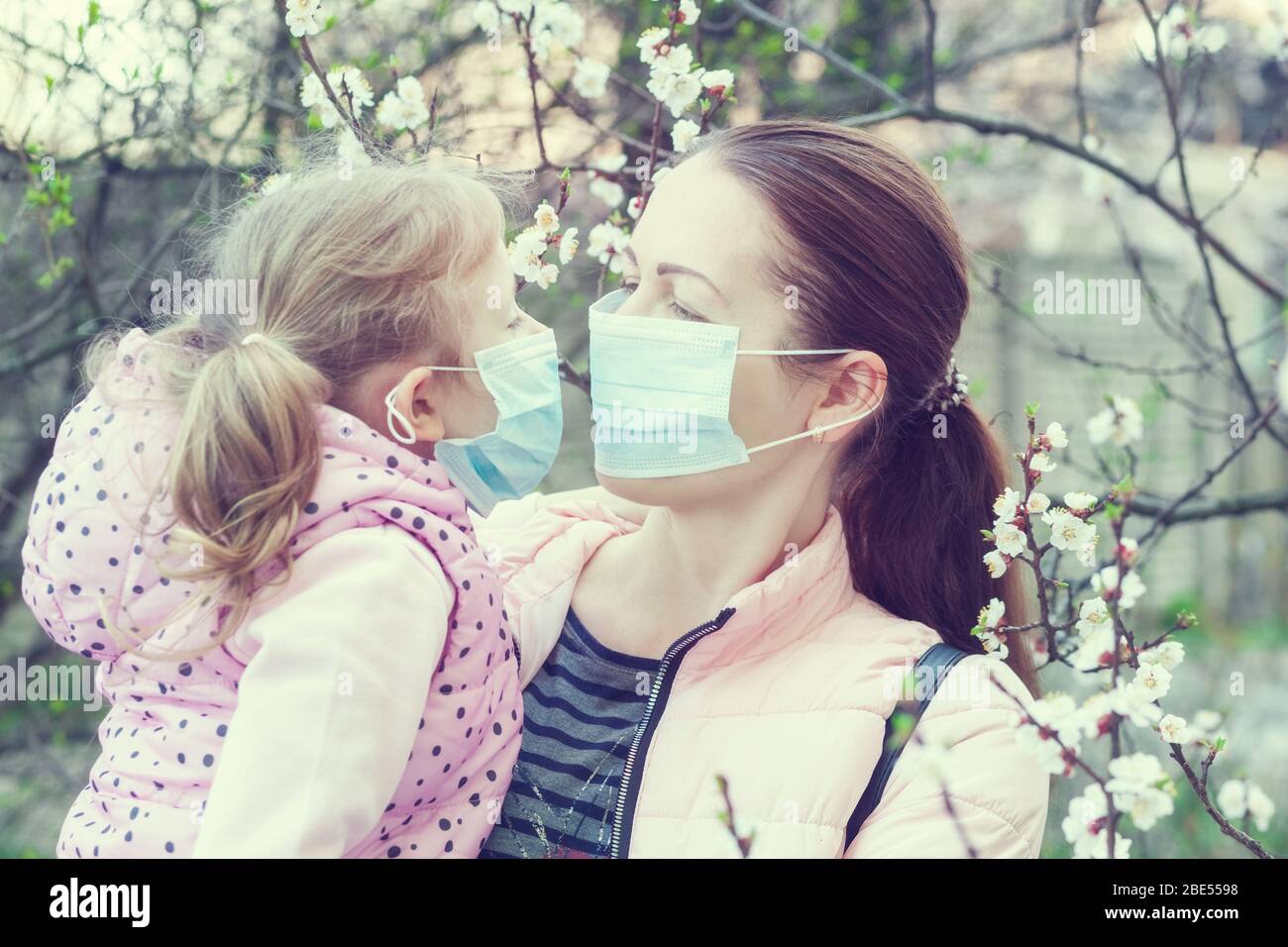 Figlia e madre indossano maschere per strada. Virus pandemico Foto Stock