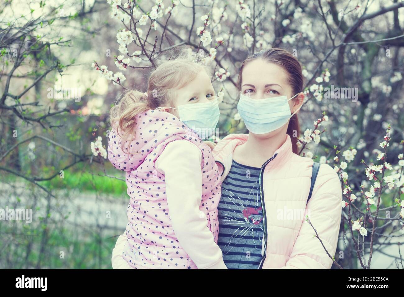 Figlia e madre indossano maschere per strada. Virus pandemico Foto Stock