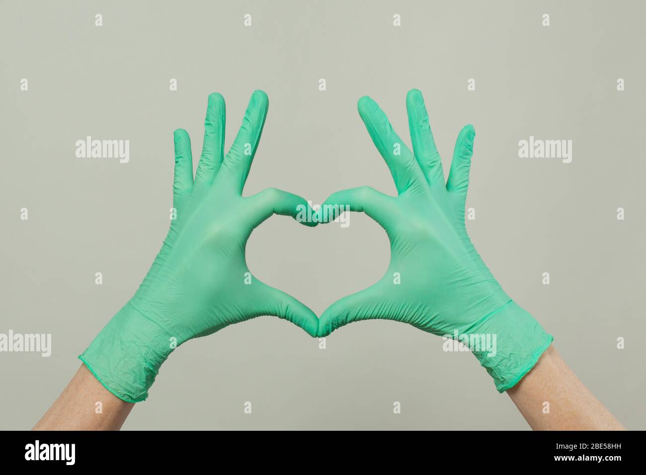 Guanti da medico. Il cuore, figura costruita dalle mani in guanti medici su sfondo bianco Foto Stock