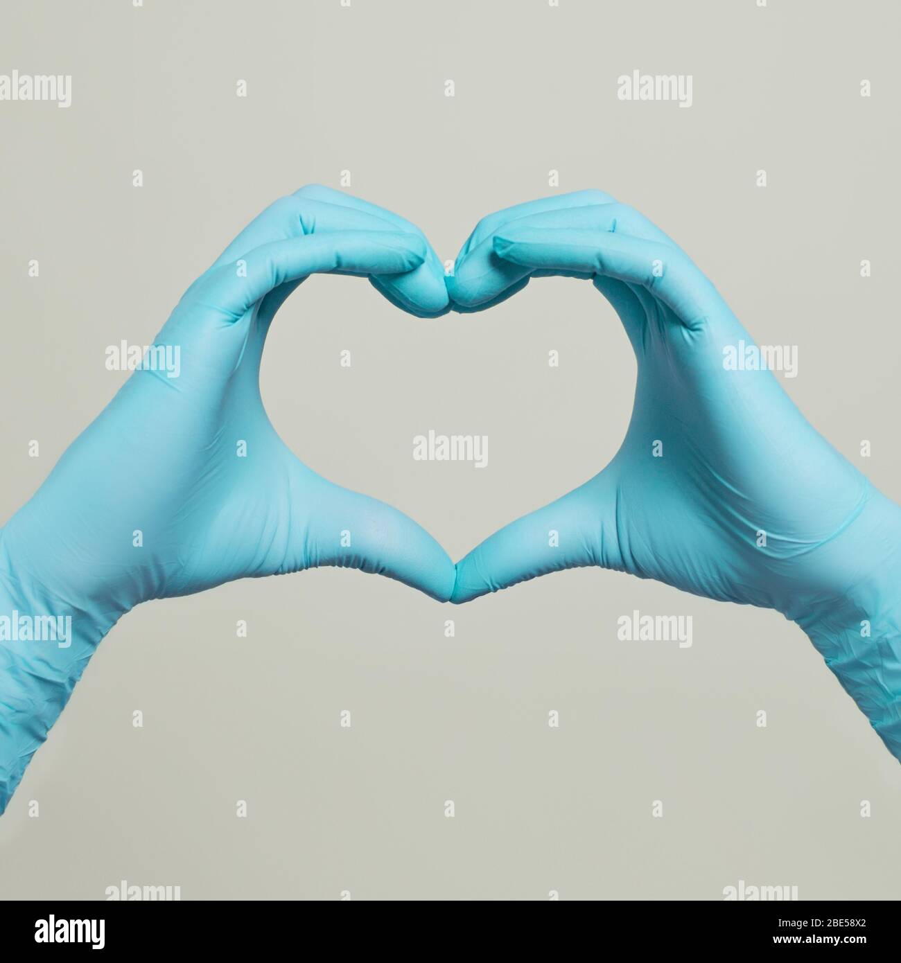Guanti per uso medico, forma a cuore mani. Guanti blu medico Foto Stock