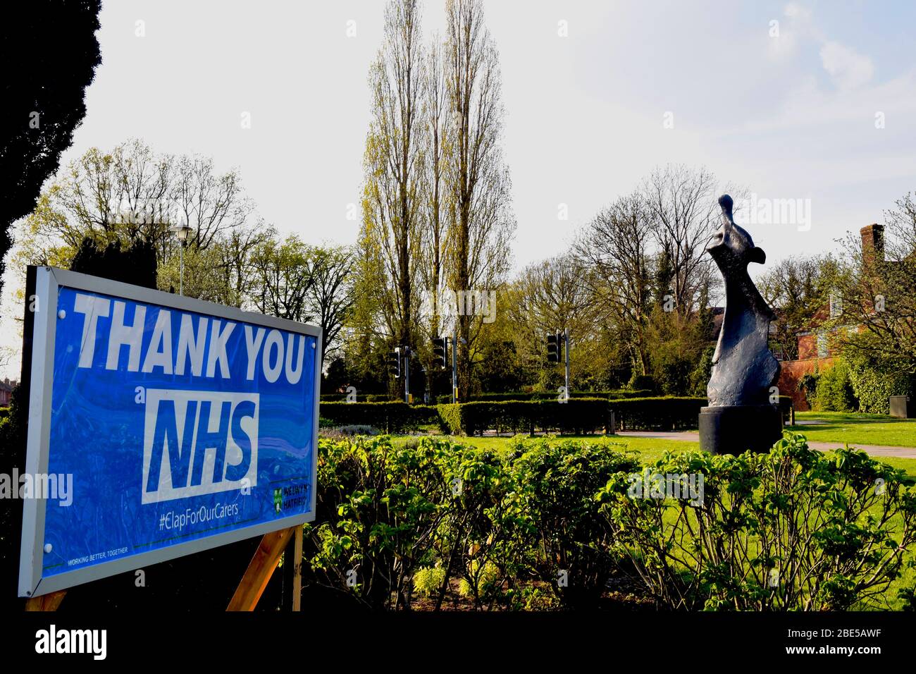 Grazie segno per i lavoratori NHS con scultura in background Foto Stock