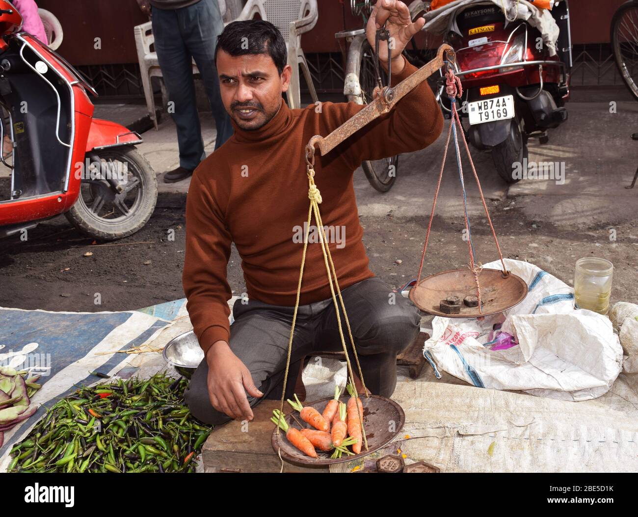 Mercato indiano del vegetale - una persona che pesa le verdure Foto Stock
