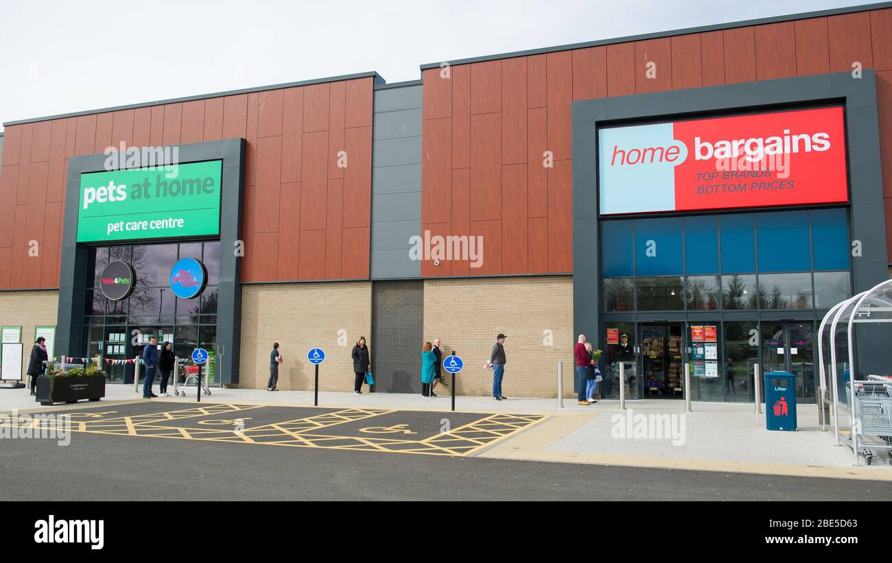 Cumbernauld, Regno Unito. 12 aprile 2019. Nella foto: Gli acquirenti si accodano fuori da un negozio di occasioni a casa mantenendo le distanze sociali. Scene durante il blocco di Coronavirus (COVID-19) da un parco al dettaglio in Cumbernauld. Gli acquirenti si accodano fuori per ottenere le loro offerte e forniture per il periodo festivo della Domenica di Pasqua. Credit: Colin Fisher/Alamy Live News Foto Stock