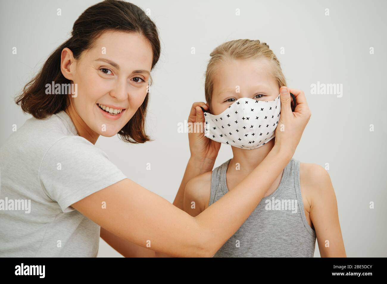 Madre e figlio, prova su una nuova maschera protettiva. Vita familiare nella chiusura Foto Stock