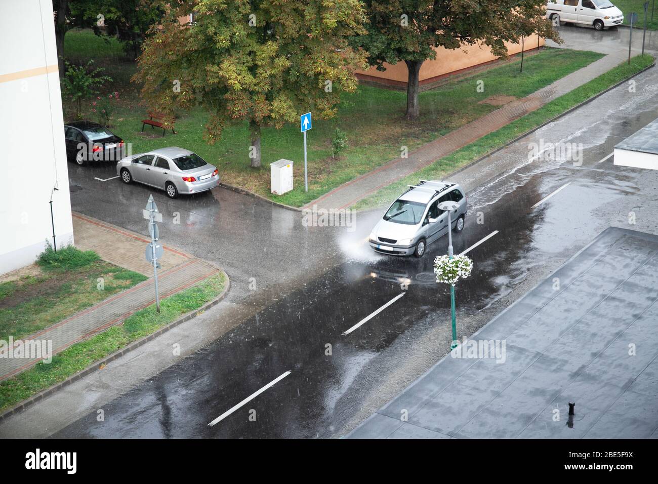 il traffico dell'automobile pioggia il grande puddle che spruzza l'acqua dalle ruote Foto Stock
