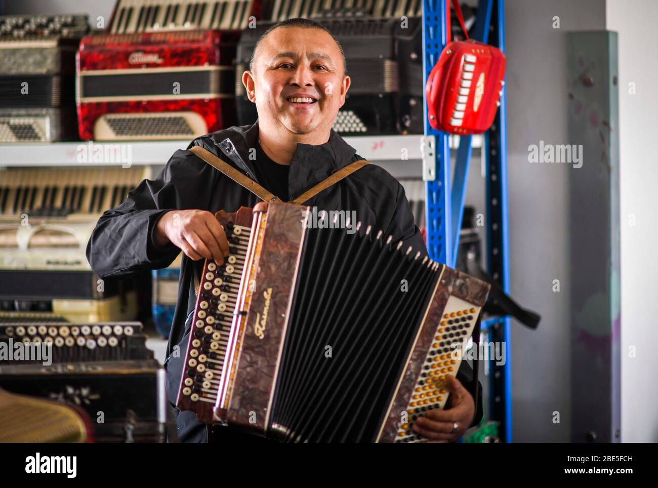 (200412) -- URUMQI, 12 aprile 2020 (Xinhua) -- Daowuran suona la fisarmonica nella sua casa a Tacheng, nella regione autonoma dello Xinjiang Uygur, nella Cina del nord-ovest, il 1 aprile 2020. La fisarmonica fa parte importante della vita della gente a Tacheng, una città dove culture diversificate si incontrano e si mescolano. Daowuran, un riparatore di fisarmoniche, ha un amore ardente verso lo strumento. Per cercare e conoscere le diverse fisarmoniche, Daowuran aveva fatto lavori part-time nei pub mentre viaggiava intorno dal 1991. Ha persino viaggiato in Russia, Bielorussia e Kazakistan per le fisarmoniche. Daowuran ha allestito uno studio nel suo seminterrato t Foto Stock