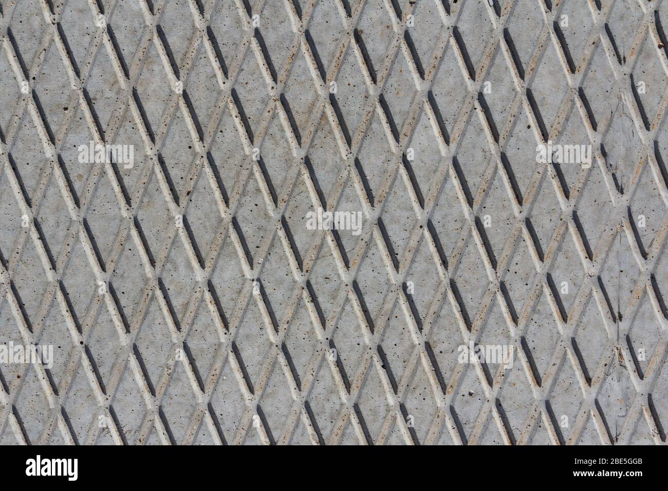 Tessitura di lastra di calcestruzzo. Soletta concreta modello rombico su una soletta di calcestruzzo closeup. Foto Stock