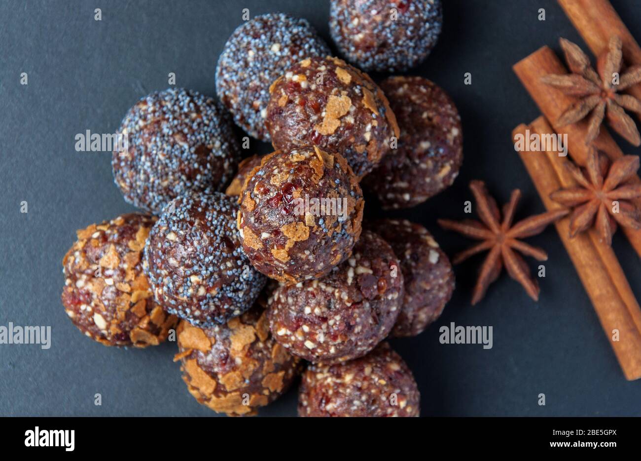 Palle vegetariane di frutta con anice stellato e cannella su sfondo nero. Dolci vegetariani di frutta. Foto Stock