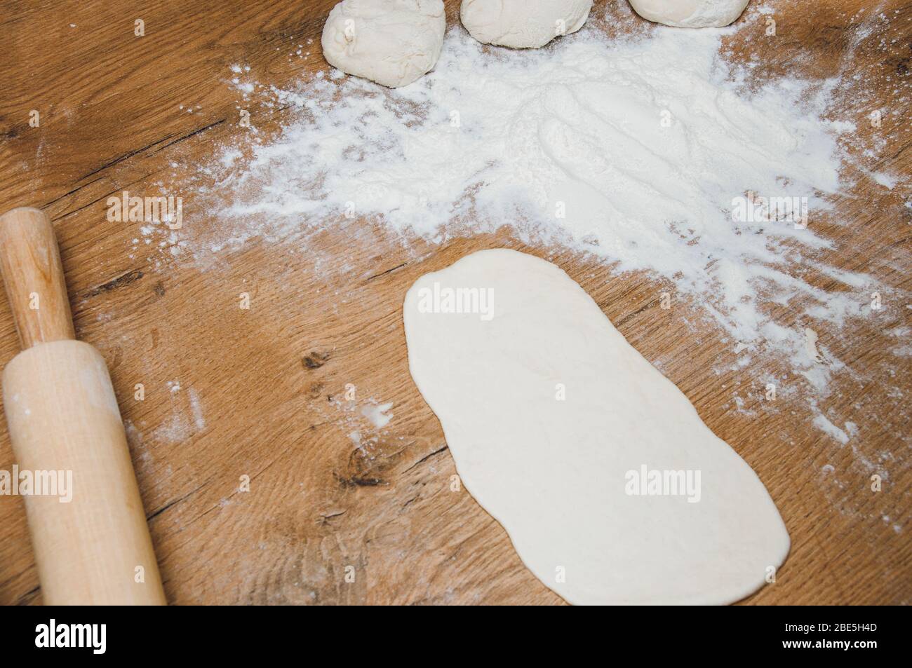 Pin di laminazione, pasta e farina sul tavolo. Il processo di fare torte fatte in casa. Cottura fatta in casa. Cottura dall'impasto domestico. Foto Stock