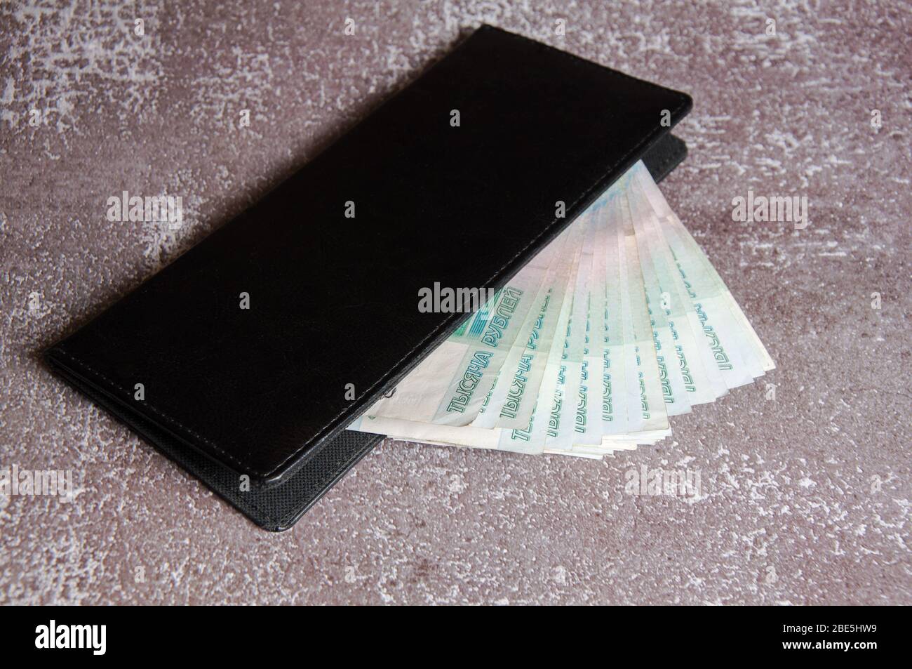 Denaro russo in un notebook nero. Pagamento per servizio. Ricompensa. Suggerimento Foto Stock