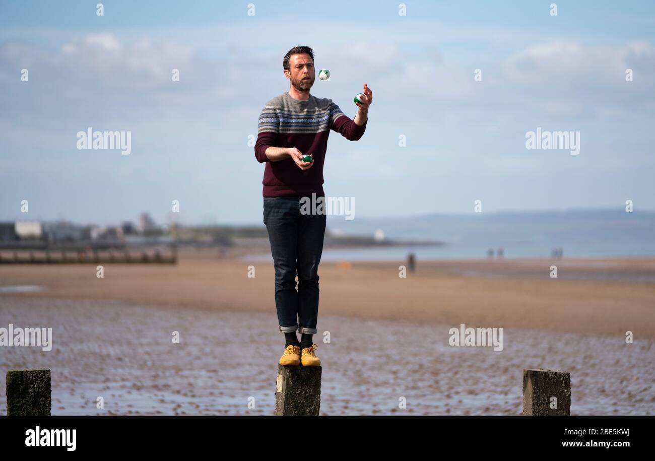 Portobello, Edimburgo. Scozia, Regno Unito. 12 aprile 2020. Domenica di Pasqua pomeriggio in tempo soleggiato il pubblico è all'aperto, allenandosi e camminando sulla spiaggia di Portobello. La spiaggia e il lungomare erano molto tranquilli e la gente si stava esercitando per lo più a distanza sociale. Nella foto; giocoleria uomo sulla spiaggia di portobello. Iain Masterton/Alamy Live News Foto Stock