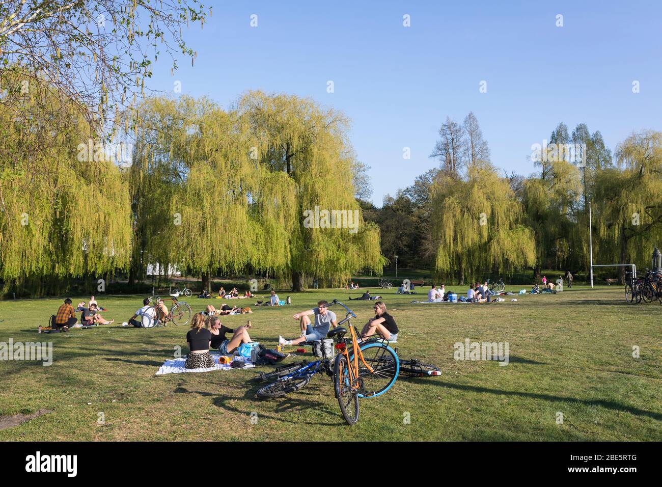 Persone che godono di una giornata di sole in un parco cittadino che soggiornano a una distanza sociale sicura a causa della crisi di Corona, Eindhoven, Paesi Bassi Foto Stock