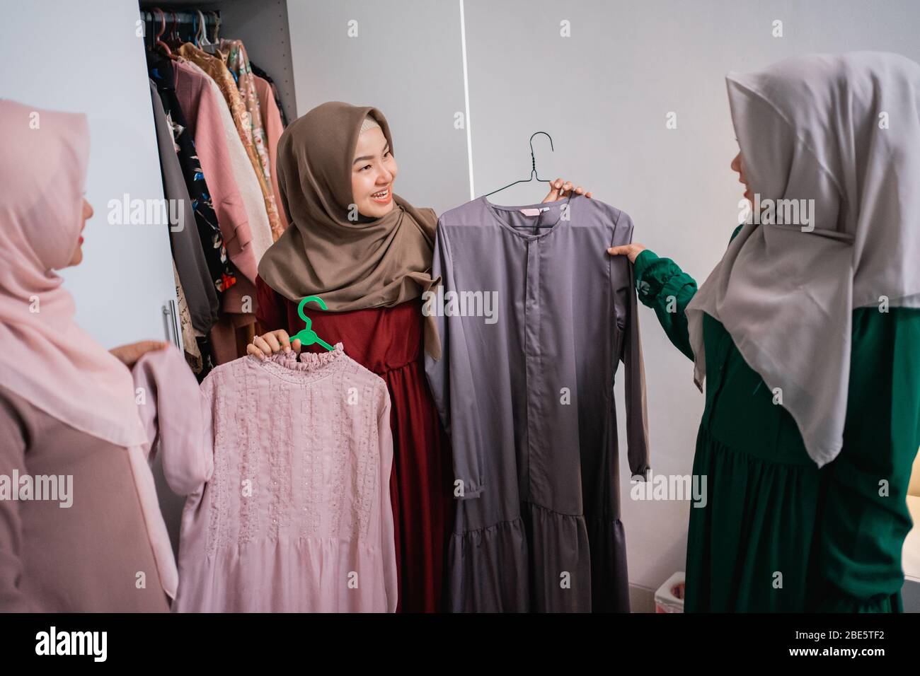 I designer di abbigliamento musulmani mostrano i risultati dei loro indumenti ai loro clienti nella casa della stanza Foto Stock