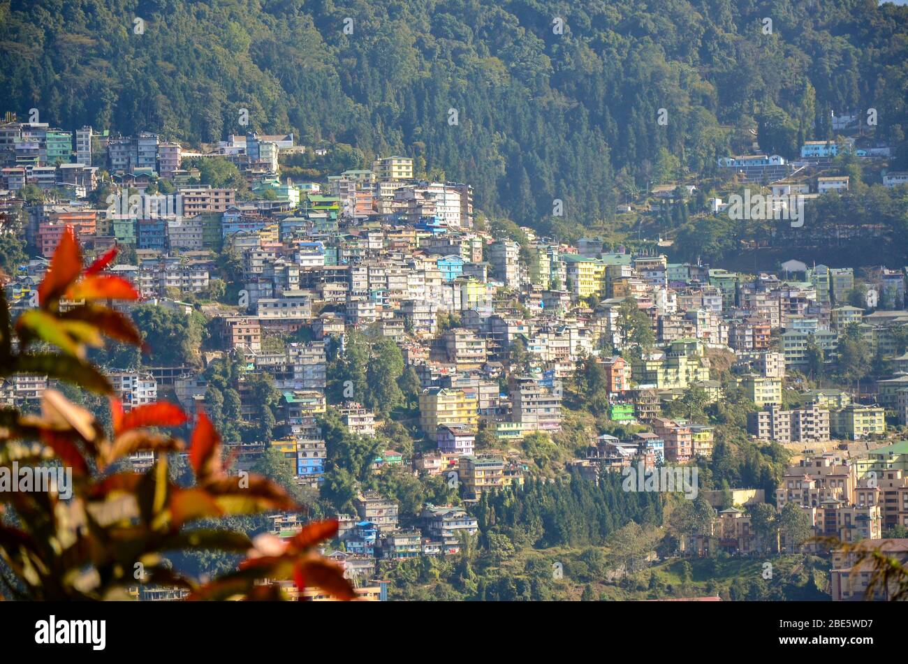 Vista del gruppo di case della città di Gangtok accoccolato sul pendio di montagna come visto da qualche parte vicino al monastero di Rumtek, Sikkim, India Foto Stock