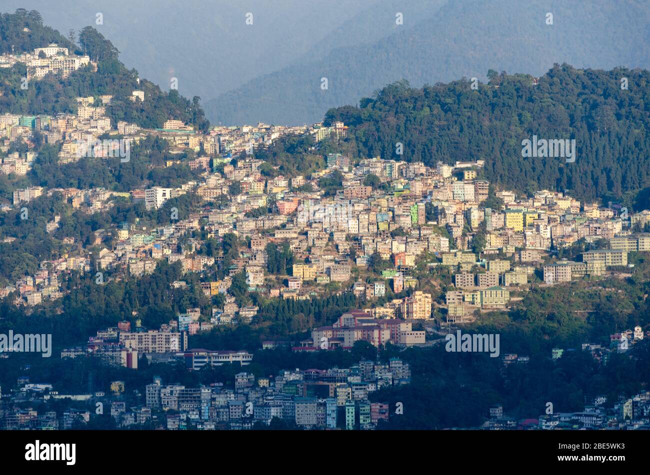 Vista del gruppo di case della città di Gangtok accoccolato sul pendio di montagna come visto da qualche parte vicino al monastero di Rumtek, Sikkim, India Foto Stock