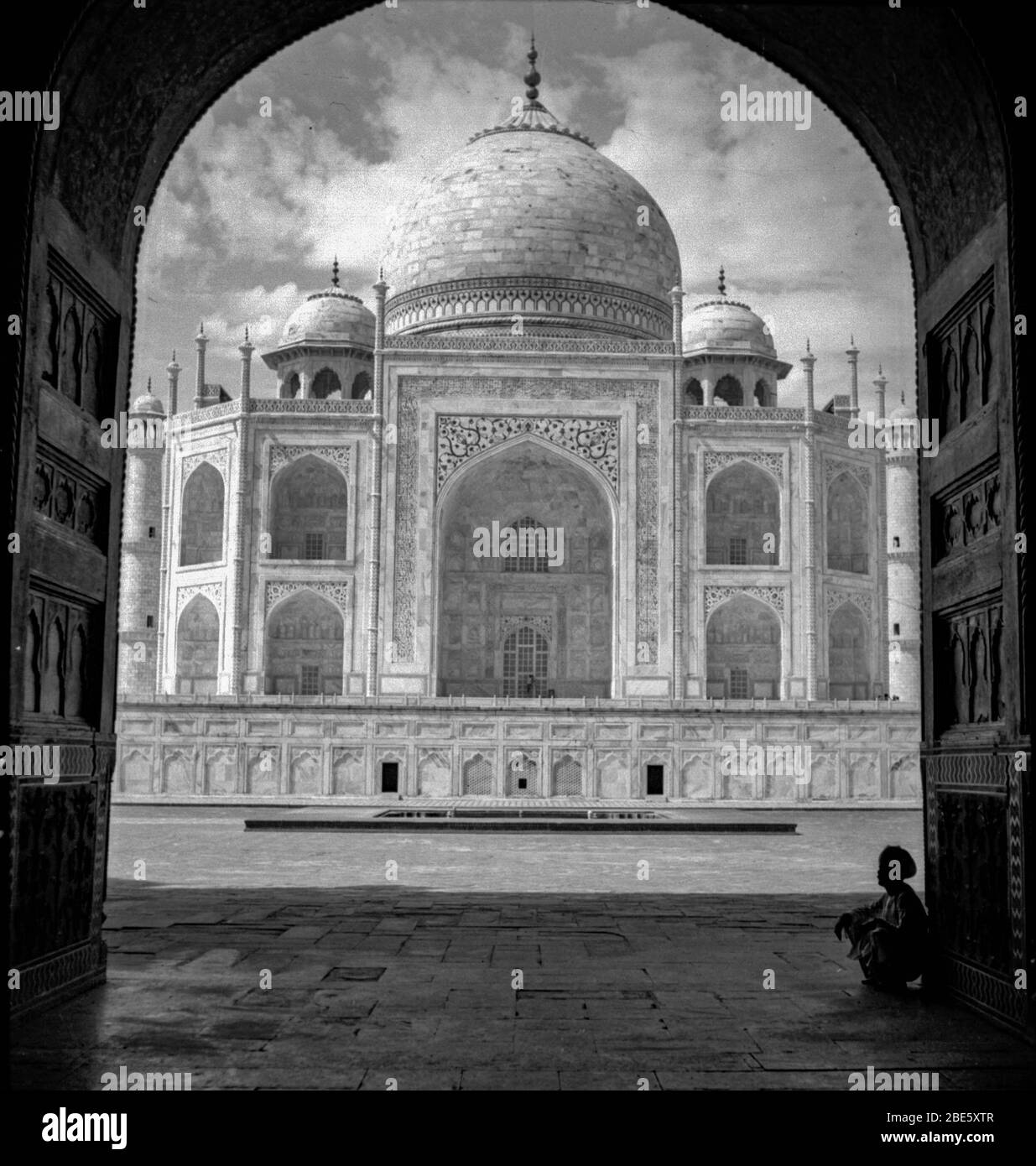 Il Taj Mahal in India gli anni '20 senza turisti intorno. E' incorniciato dalle porte di legno per la Moschea di Kau Ban. Foto Stock