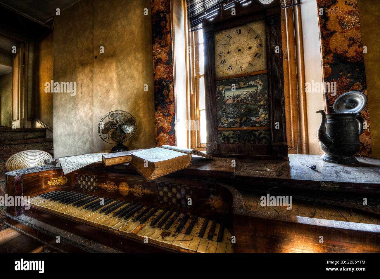 Pianoforte e orologio e oggetti d'antiquariato in una casa abbandonata Foto Stock
