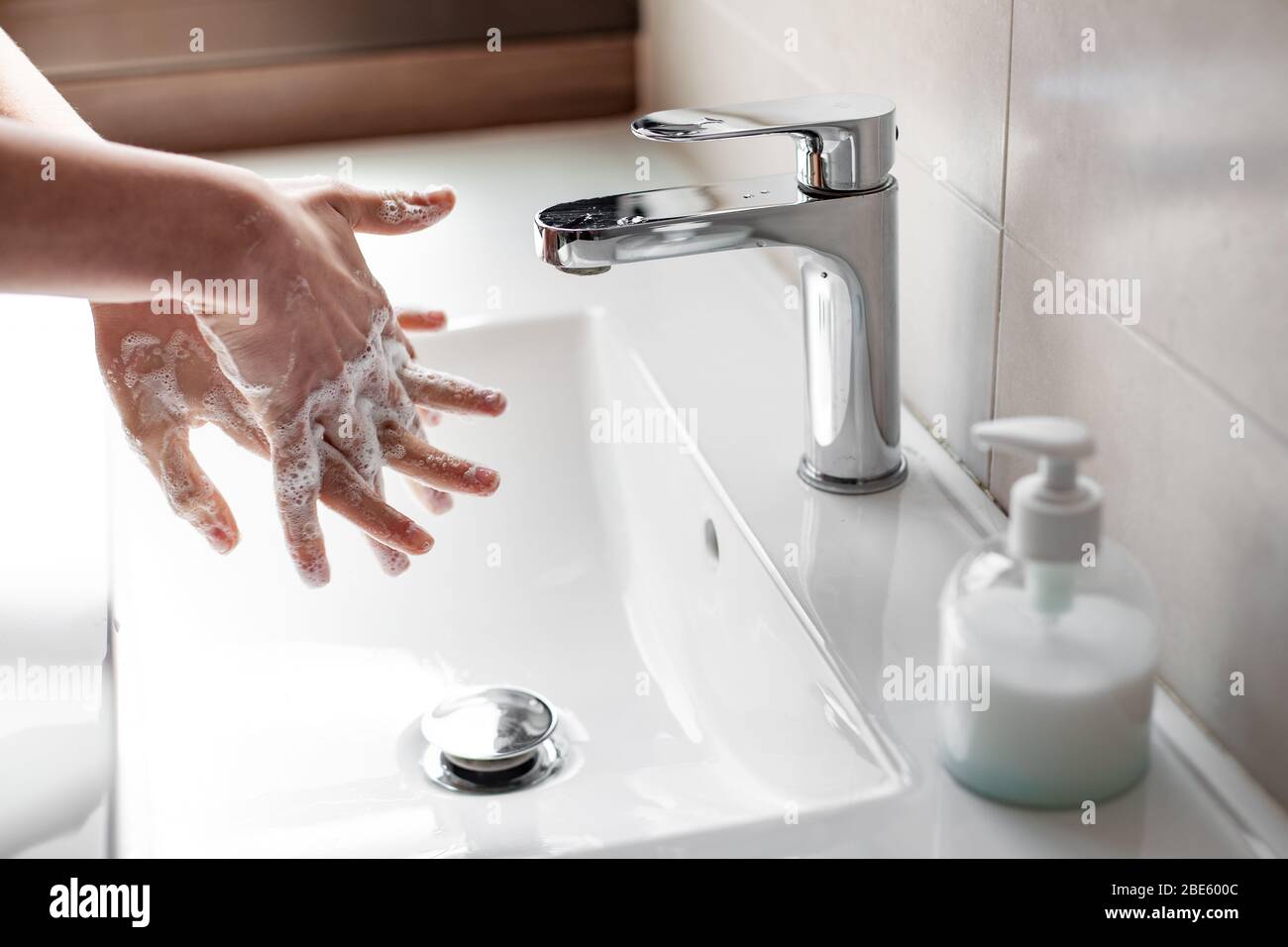 Lavare le mani con sapone per prevenire l'infezione da coronavirus Foto Stock