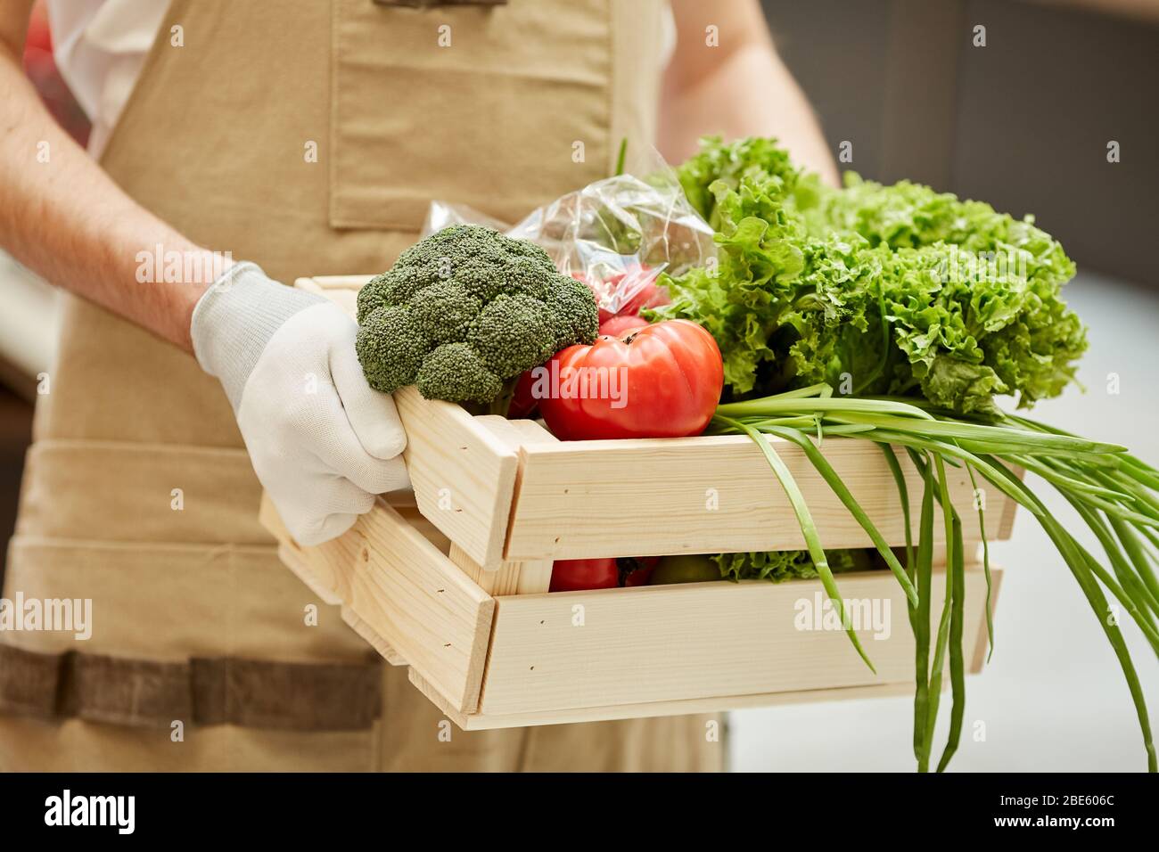 Primo piano di uomo irriconoscibile che tiene scatola di verdure mentre vende prodotti freschi al mercato degli agricoltori, spazio copia Foto Stock