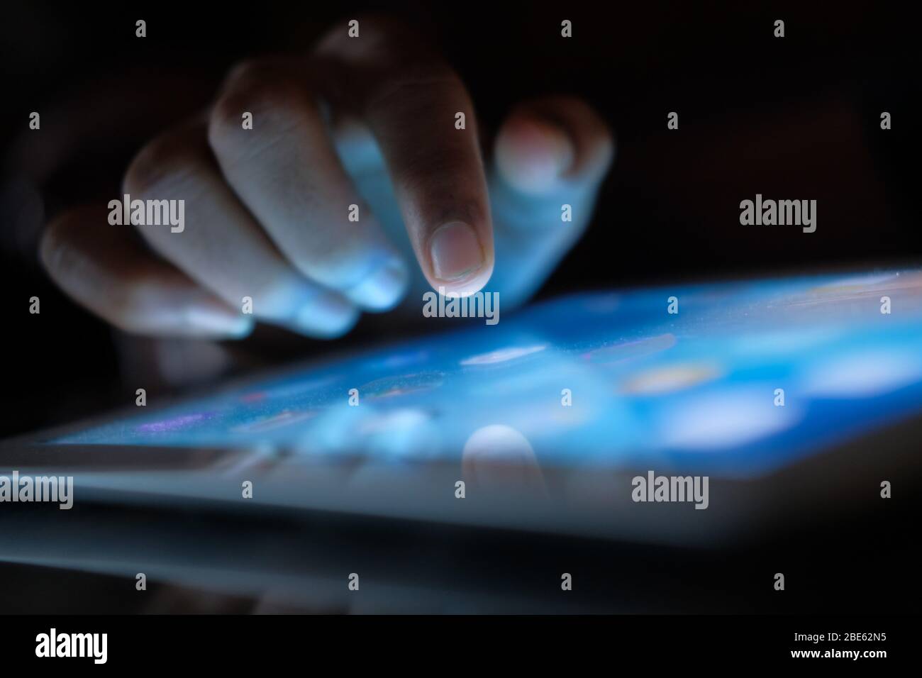 Primo piano della mano dell'uomo con un tablet digitale di notte. Foto Stock