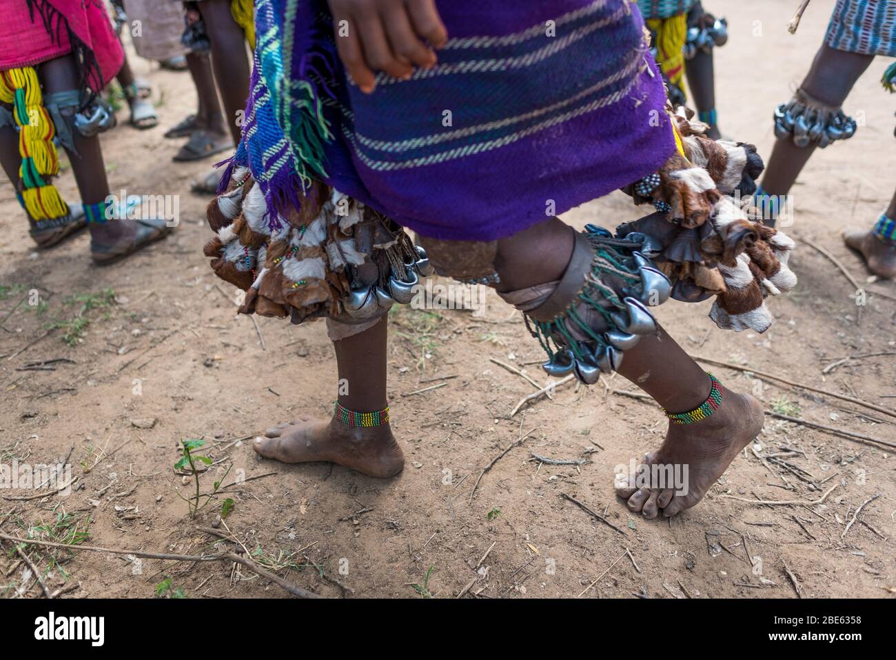 Ballerini con campane sulle gambe a Mursi tribù etnico gruppo venuta di età bull jumping cerimonia, Jenka, Etiopia, Foto Stock