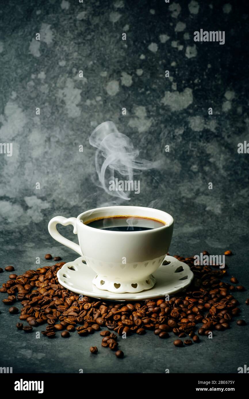 Caffè di fondo. Caffè in chicchi e tazza su fondo scuro. Banner caffè per menu, design e decorazione. Foto Stock