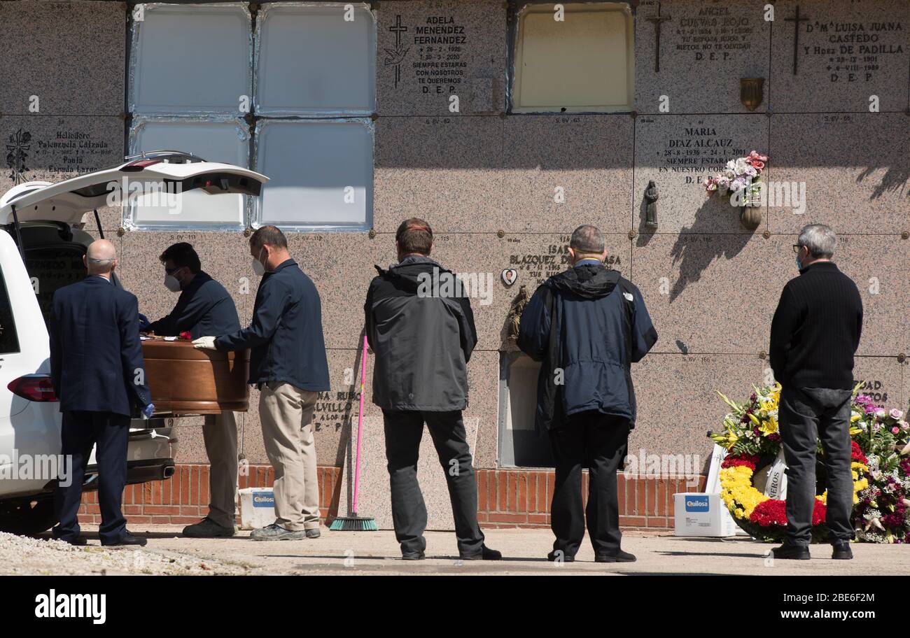 Spagna - Madrid - 12 aprile 2020 - lavoratori funerari pronti a seppellire una bara nella Cementeria meridionale di Madrid - i servizi funerari sono stati limitati ad un massimo di tre parenti a causa della crisi sanitaria causata dal coronavirus. Foto Stock
