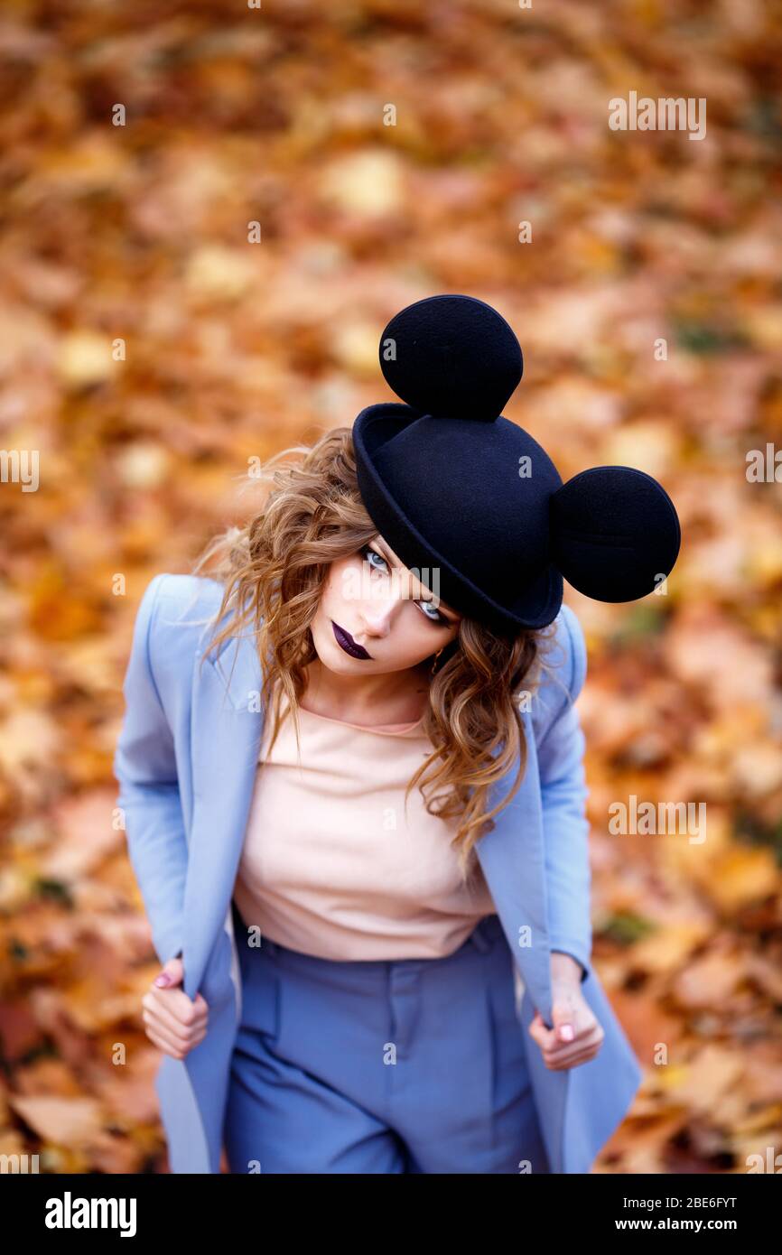 Ragazza carina per strada in un cappello divertente. Partenza in autunno.  Le orecchie di Topolino Foto stock - Alamy
