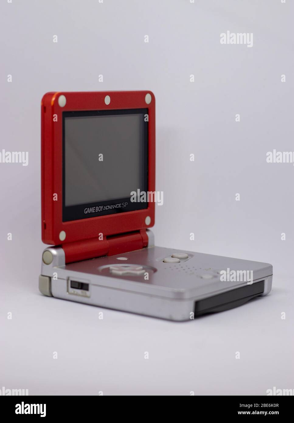 Game boy Advanced SP console portatile da Nintendo da 2003 in rosso argento Super Mario Edition. Aperto, spento con gioco inserito su bianco Foto Stock