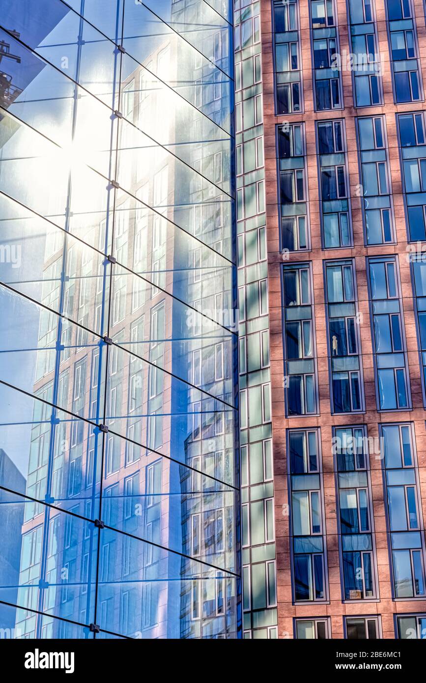 Facciata con riflessi multipli di altri edifici e il sole a New York Foto Stock