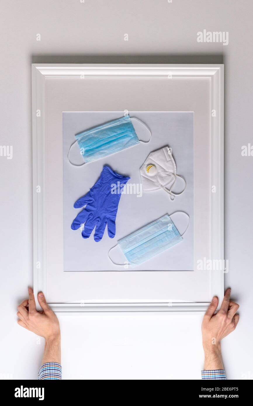 Lost anno 2020 concept.Man appende sul muro un quadro sul tema della pandemia di coronavirus in tutto il mondo e oggetti protettivi per aiutare a combattere il vi Foto Stock