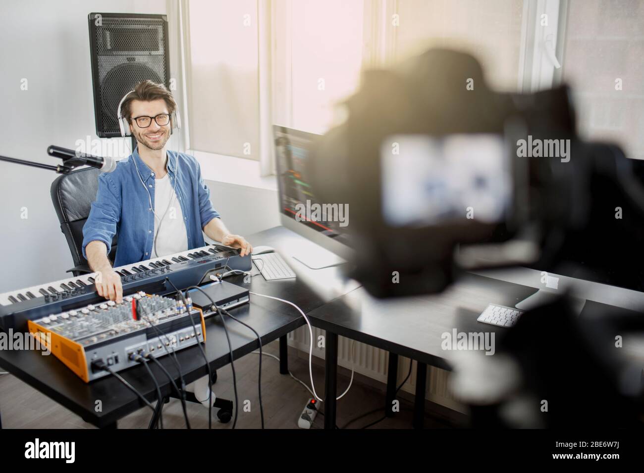 Il video blogger dal vivo insegna a rendere live le tracce musicali. Video per social network o streaming. DJ in studio di trasmissione. Produttore di musica è Foto Stock