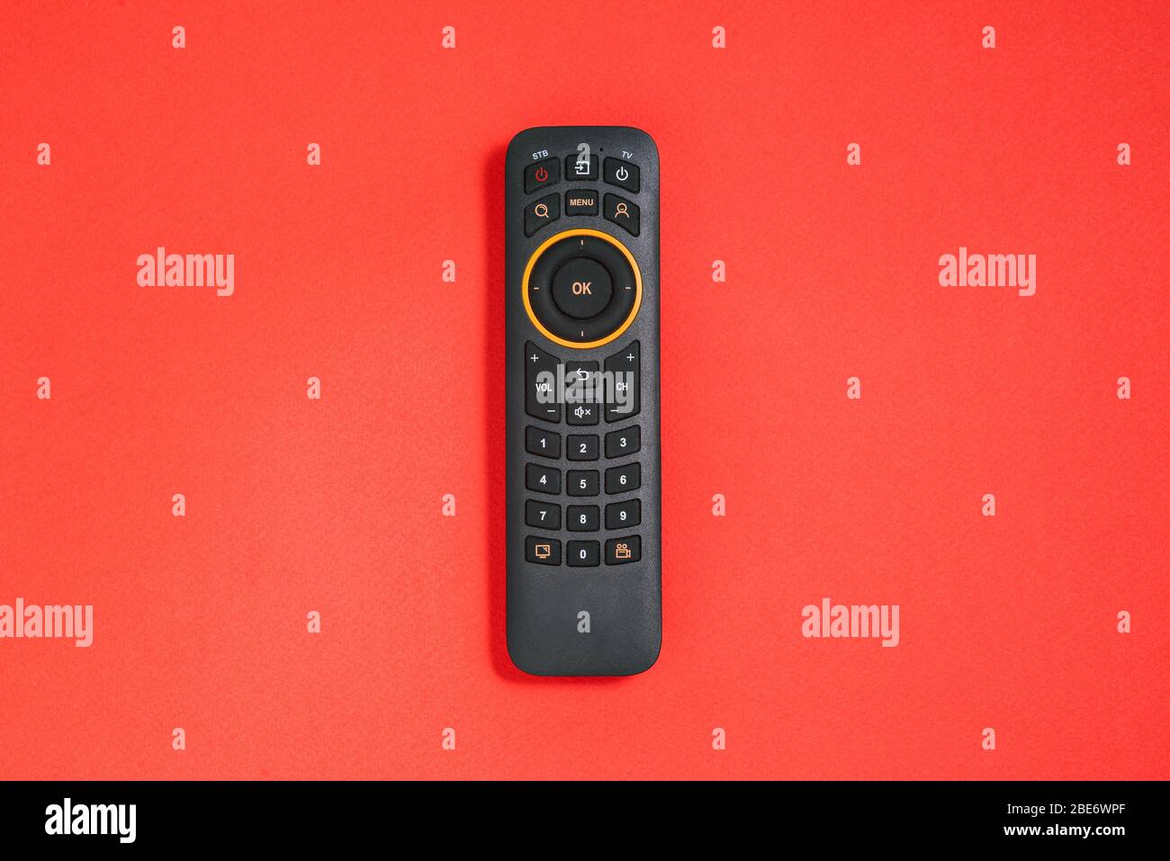 Telecomando con pulsanti su sfondo rosso. Concetto Smart TV. Home Entertainment Foto Stock
