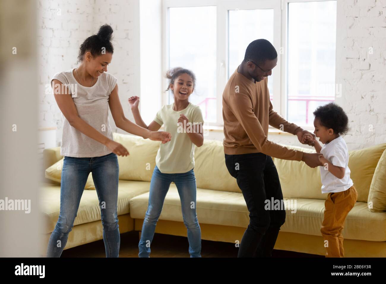 Felice madre e padre afro-americano con due figli che ballano. Foto Stock