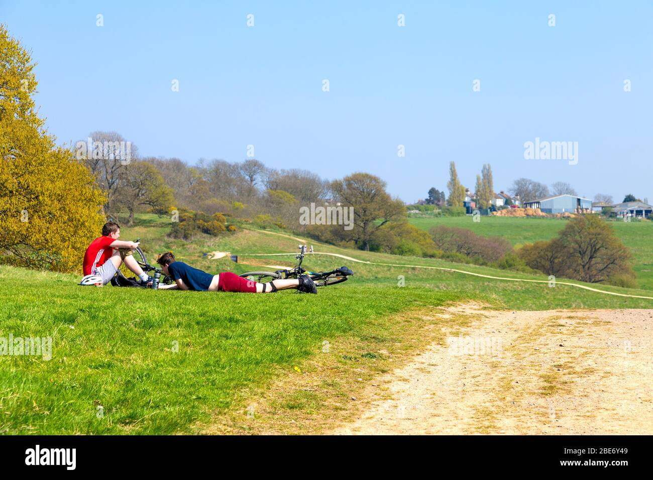 Ciclisti che riposano sull'erba al Parco di Hadleigh, Essex, Regno Unito Foto Stock